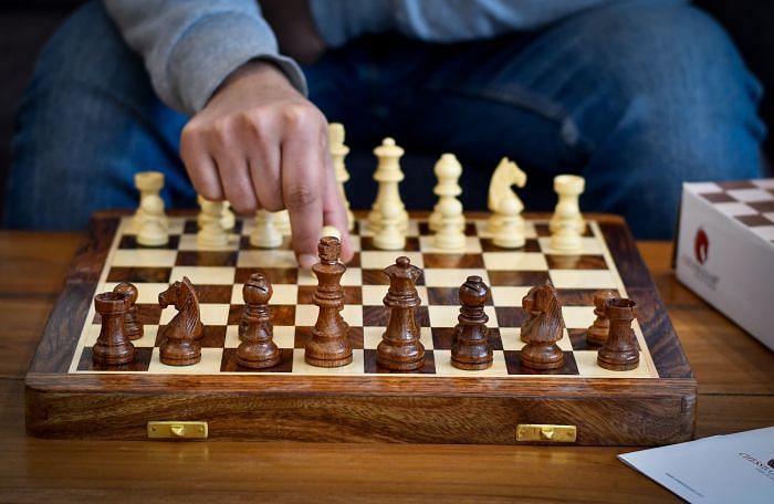 Player making a move on 14 inch travel chess set by chessbazaar