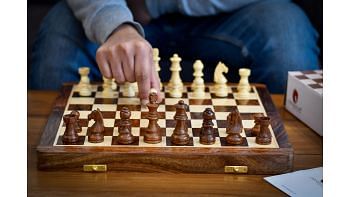 Player making a move on 14 inch travel chess set by chessbazaar