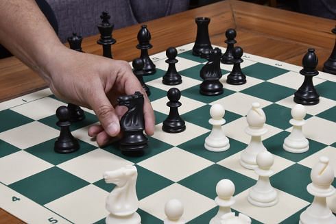 Plastic chess pieces on a rollup chess board