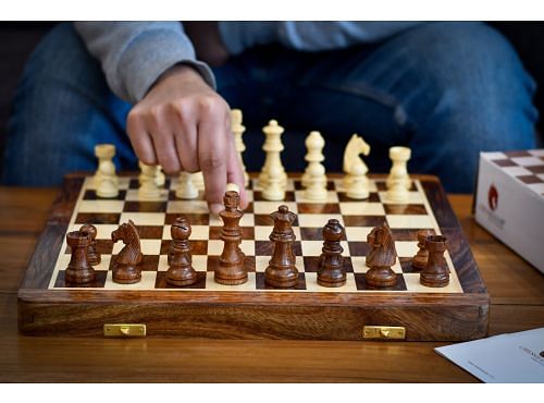 Player making a move on 14 inch travel chess set by chessbazaar